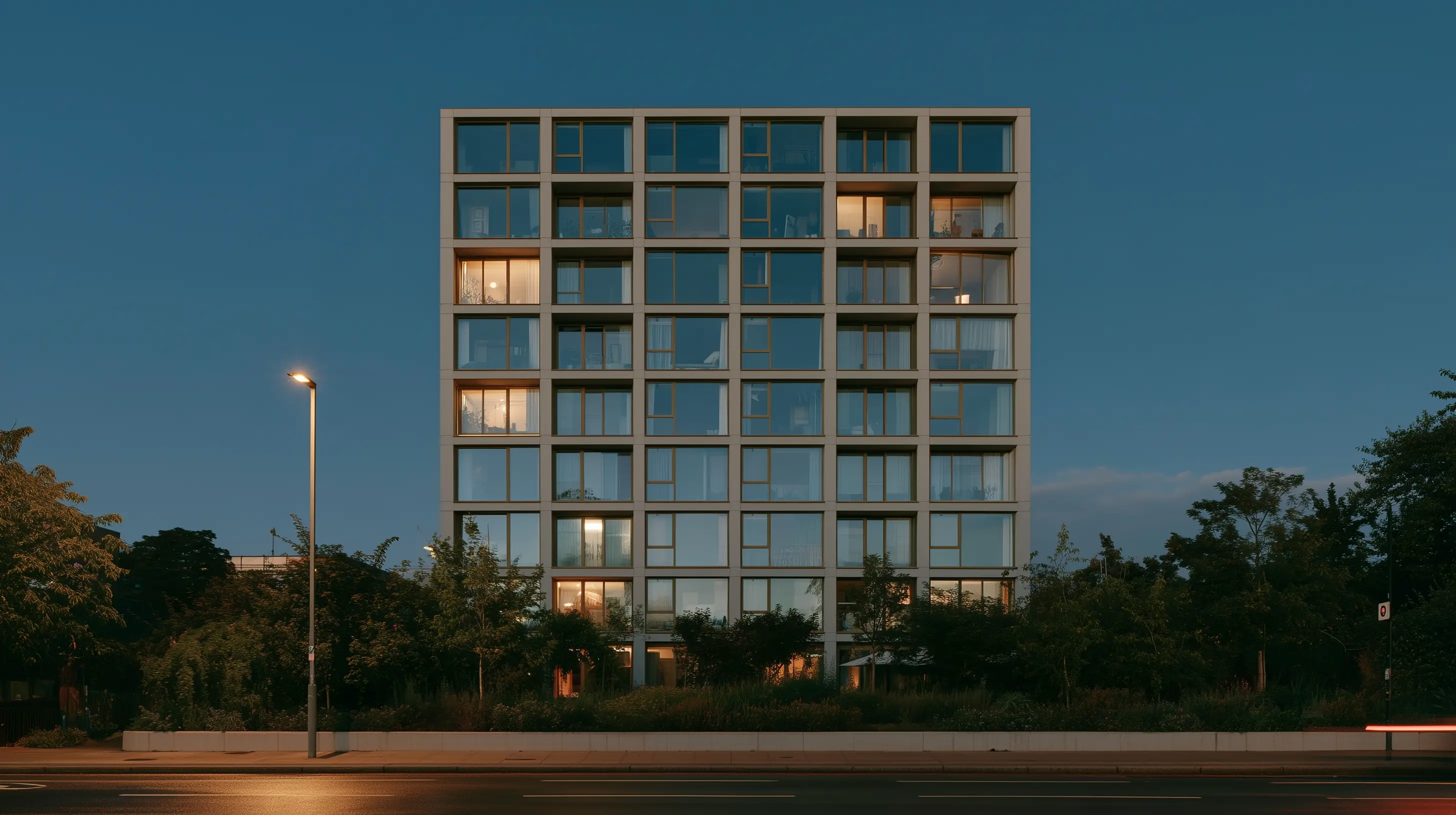 A residential building at night, most of its windows lit